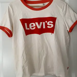 En vit Levis tröja med orangea detaljer. Begagnat skick. Frakten är inte inkluderad i priset då jag inte vet helt 100 vad den blir. Köparen står för frakt.  Allt som säljs kommer från ett rent djur- och rökfritt hem.