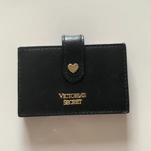 Korthållare  - Svart korthållare från Victorias Secret med färgglada kanter. Man stänger den med hjälp av en knapp på framsidan. Får plats med flera kort i samma fack. Använd men är i väldigt bra skick!! Köparen står för frakten🌸
