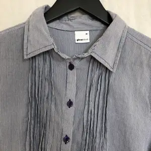 Snygg lång skjorta ifrån Gina Tricot i blå/vit randigt tyg med snygga detaljer, använd fåtal ggr. 