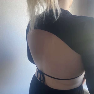 Svart tröja med öppen rygg - Enkel oanvänd tröja med öppen rygg. Prislappet sitter kvar och fraktkostnad på 50kr ( Liten i strl )