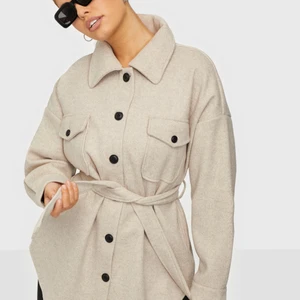 Nelly kappa - Säljer min jätte fina beiga kappa från Nelly då den va för stor för mig, prislappar finns kvar! (Bild från hemsidan) Kan även skicka egna bilder på kappan