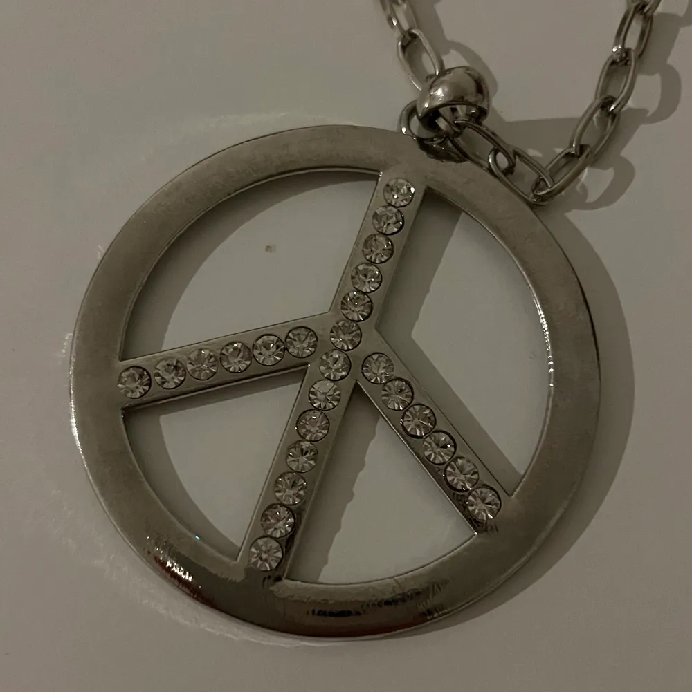 Peace halsband i silverfärg andvänd endast 2-3 ggr. Accessoarer.