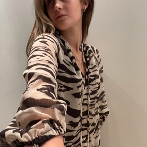 Klänning  - Klänning i zebra-aktigt mönster, köpt i somras men endast använd 2 ggr. Kan mötas upp i Stockholm, annars står köparen för frakt!💕