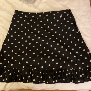 Kjol från Nakd Strl 38 - Kort blå prickig kjol från nakd. Normal Storlek.  Säljer eftersom att den är för liten. Notera att knäppet är lite löst men inte sönder och fungerar men om man vill att de ska vara bättre kan man du dit en ny tråd vid midjan. 