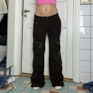 Lågmidjade cargopants - Lågmidjade, bruna cargobyxor i Manchester tyg! Jättetrendig brun färg och ganska mjuka och sköna i tyget men många olika fickor! midjemått: 41cm innerbenslängd: 82cm