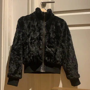 Fuskpäls jacka  - En jättesnygg svart fuskpäls jacka med lila silke i, från Lindex. Tyvärr för liten för mig