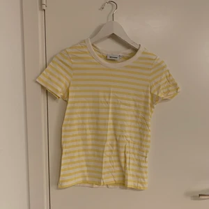 Randig T-shirt från Weekday  - Randig gul/vit t-shirt från Weekday i strl XS som inte kommit till användning. Som ny. 