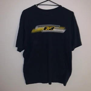 Reebok Tisha - Mörkblå reebok tisha i storlek herr M med najs boxy fit