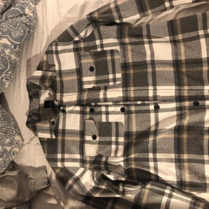 Skjortjacka! - Snygg skjortjacka ifrån HM som såldes förra vintern! Använd 0 gånger då det inte kommit läge helt enkelt. Färgerna är Grå, vit och beige. Storlek L. Nypris 500