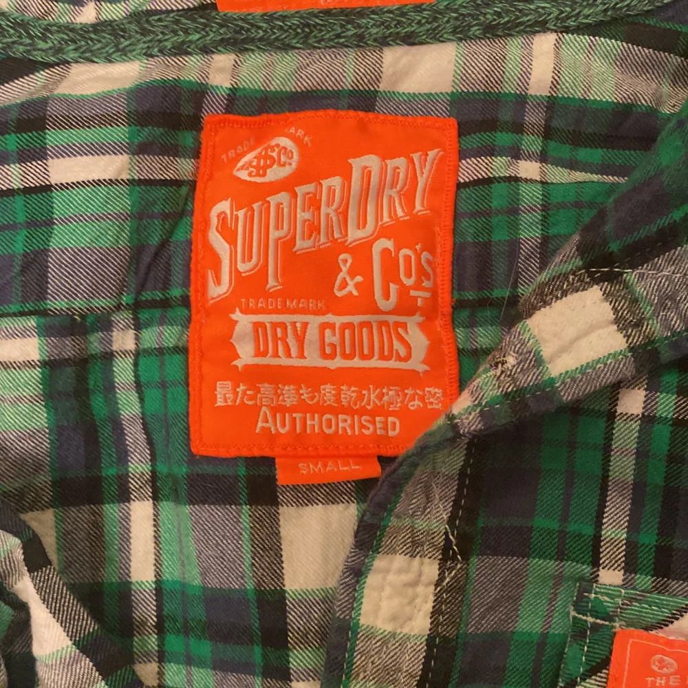 Superdry skjorta i grön rutig färg med orangea detaljer. Storlek small. Använd men i bra skick! Kan skickas men köparen står för frakten.. Skjortor.