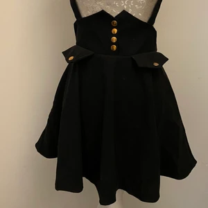 Söt kjol med hängslen  - Högmidjad supersöt kjol med hängslen med rosett på baksidan. Storlek S. Använd endast en gång!