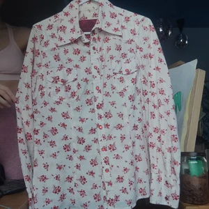 Blommig kitch skjorta - Off White med röda blommor. Gyllenröda knappar (se bild). Kan ej tyda märkeslappen 🥲