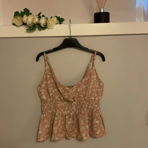 Oanvänd kort söt topp stl S - Gammalrosa topp med småblommor. Justerbara axelband och resår under brösten. Oanvänd i stl S.
