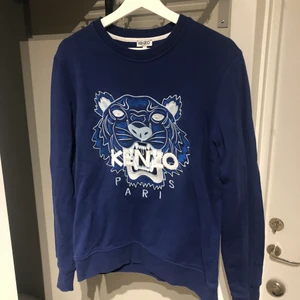 Kenzo tröja strl L - Säljer en riktigt snygg blå Kenzo tröja i storlek Large. Ganska liten i storleken, sitter perfekt på mig som är 186cm och vanligtvis har small/medium i kläder. Som synes på sista bilden är det två små hål i tröjan, på ryggen nedanför vänster axel. Sätter därför ett lågt pris. Mötes upp i centrala Linköping eller så postas tröjan. Vid det senare alternativet står köparen för frakten. 