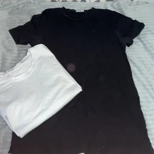 En svart och en vit t-shirt 2 för 1😜 - Den svarta är lite längre i modellen me korta ärmar i storlek L, den vita är kortare i modellen med korta ärmar i storlek L. (Ops den vita-t-shirten har en fläck på som it går att ta bort). Där av får du med den gratis säljer den svarta för 80 Kr