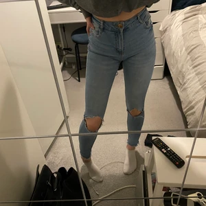 skinnyjeans - ljusblåa skinnyjeans med hål i knäna och slitningar längst ner