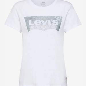Vit Levis tröja med Levis märket omringat av silver. Är i storlek S! Använd fåtal gånger så är fortfarande i mkt bra skick!  Köparen står för frakten på 48 kr!