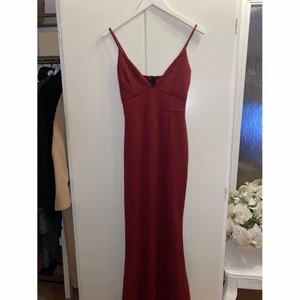 Vinröd långklänning med slits - En jättefin, stretchig vinröd långklänning med slits. Helt oanvänd med lappen kvar från Missguided. Sitter fint på kroppen och framhäver former. Storlek 38