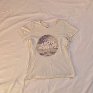 Arctic monkeys tröja / T-shirt  - Asball artic monkeys tischa köpt för flera år sedan. Jättefin men använder den inte tyvärr. Bakom själva loggan är hologrammönster🪐🦄 Perfekt om du vill jobba på din ”t-shirt and ties combination” 😉