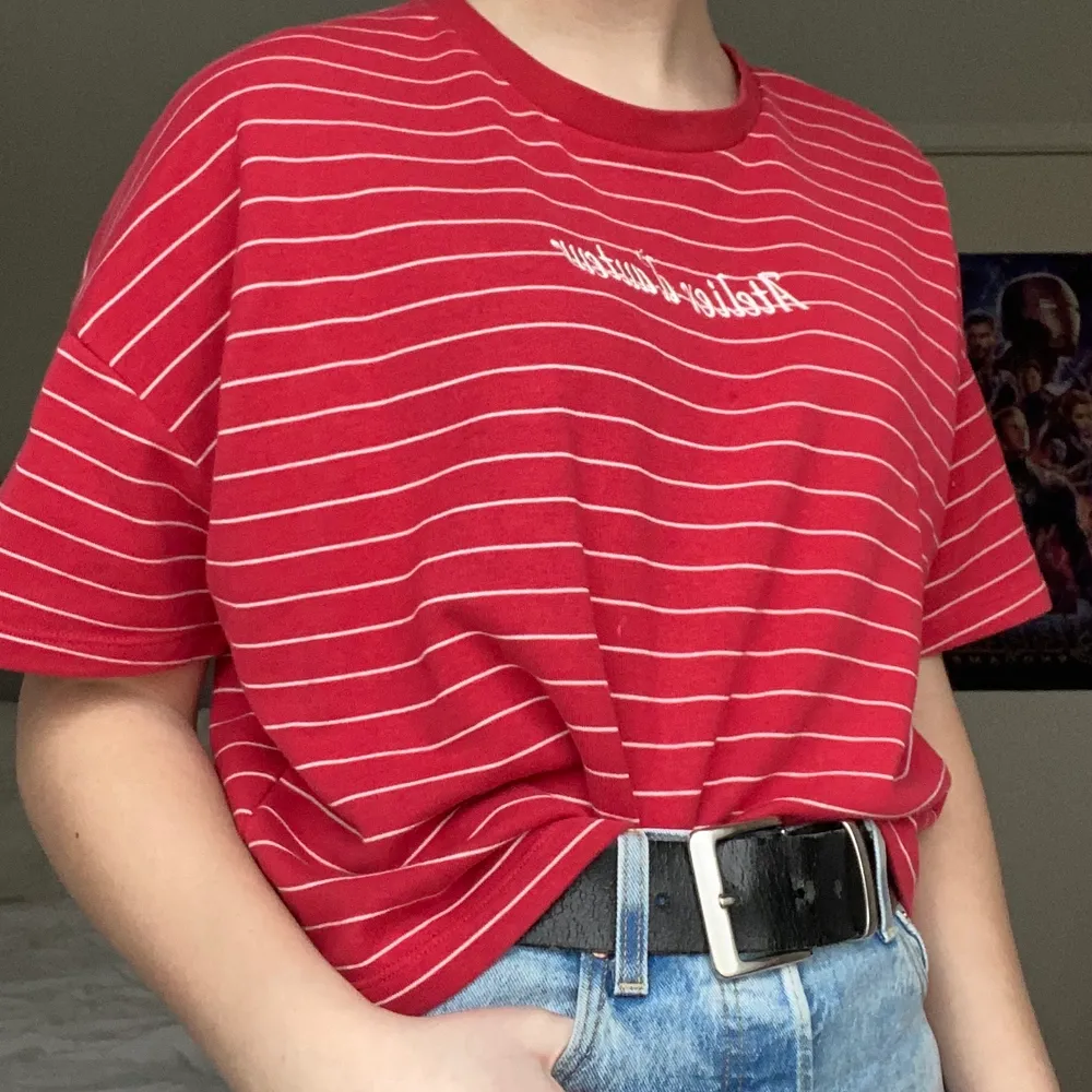 En röd och vit randig t-shirt från H&M divided med broderad text. Tyget är lite tjockare än en vanlig t-shirt. Använd men i bra skick . T-shirts.
