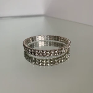 Armband med strasstenar/ oanvänt/ silverfärgat  - Oanvänt strassarmband med resor. Silverfärgat med stenar i glas. Frakt: 12 kr. Säljes då det inte kommit till användning :)