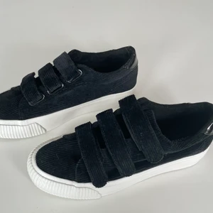 Sneakers - Helt nya och oanvända skor från Even&Odd. De har kardborrband och är i svart manchester tyg med vit sula och en en detalj där bak i lack! De var för stora för mig och kan inte längre skicka tillbaka då de gått för lång tid. Storlek 38