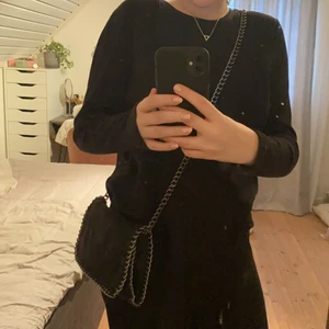 Väska - Svart med lite silver glitter väska med silver detaljer. Man kan båda ha den som axelväska och så som på bilden. Köpt för c 350kr 