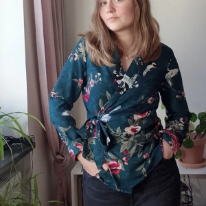 Stl 32/34 Grön omlott Kavaj/blus, Happy Holly - Snygg grön kavaj-liknande omlott tröja från Happy Holly. Mörkgrön med blommor och fåglar. Storlek 32/34