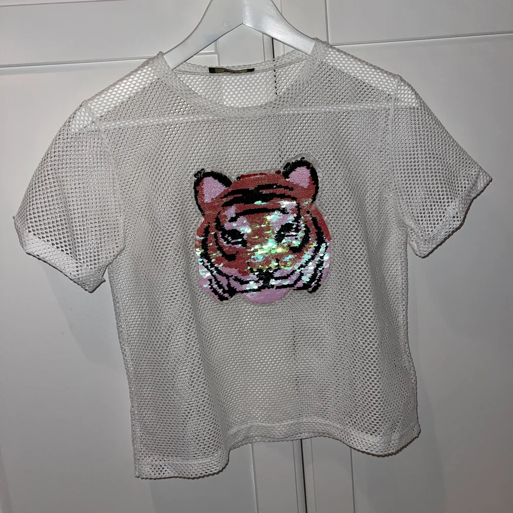 Säljer min T-shirt som har en tiger på med paljetter som man kan dra ner och upp för att ändra färg, jättefin under en långärmad tröja eller vad som helst, använt 1 gång . T-shirts.