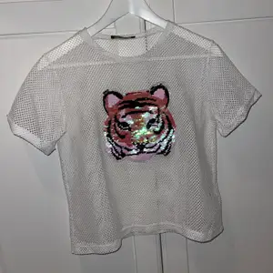 Säljer min T-shirt som har en tiger på med paljetter som man kan dra ner och upp för att ändra färg, jättefin under en långärmad tröja eller vad som helst, använt 1 gång 