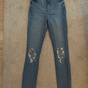 Gina Tricot - skinny jeans med hål strl 34 - Skinny jeans från Gina Tricot, använd ett fåtal gånger med bra skick. Är 175 cm och på mig har de blivit ganska korta, men det är mycket stretch i dem. Köpta för cirka 500-600kr, utgångspris är 140kr. Kan skickas mot fraktkostnad men vet ej exakt vad priset på frakten är så det som skrivs som fraktkostnad är inte 100%🥰