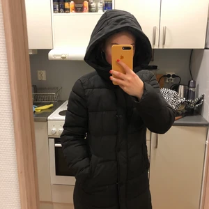 Vinterjacka - Lång svart vinterjacka i fint skick, förutom att färgen blekts lite på luvan, inget som märks. Strl XS, men passar mig som vanligtvis bär S.