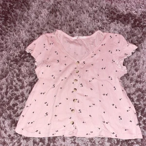 En rosa tröja från H&M srl 146/152 - Rosa tröja, med bruna knappar, urringad 