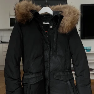 Hollies jacka  - Hollies jacka storlek 36, köpt för några vintrar sedan. Fint skick men har blivit ”glansig” på partiet som ser fläckigt ut i mitten. Ser värre ut på bild och inte alls lika tydligt i verkligheten! 