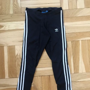 Adidas byxor - Marinblå adidas tights i storlek 34/36. Säljer pga för små för mig. De har tyvärr tre små hål längs med sömmen på rumpan och de är lite genomskinliga. Därför säljs de till ett BILLIGT pris. Frakt tillkommer!! Valfritt frakt alternativ via postnord. Jag kan också mötas upp.