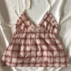 Rutig rosa halterneck  - Söt rosa halterneck i ett rutigt mönster. Passar flera storlekar då den är försedd med resårband vid midjan. Sitter bra på mig som bär S. Köpare står för 24kr frakt. Plagget är i gott second hand skick utan synliga defekter. Högsta bud 190!  Fortgår tills plagget markeras sålt så buda privat! Du vinner om ingen budar mer än dig på 24h. KÖP DIREKT FÖR 200