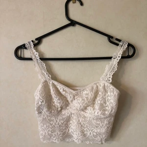 Topp Strl. XS - Tunn magtopp i en spetsmodell. Cremevit. Ingen vaddering. Lite genomskinlig. Kanske mer som en bustier. Frakt tillkommer. 🌟