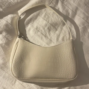 Vit axelväska - Liten ”off white” axelväska från shein i skinnimitation. Bra skick då den aldrig är använd. Säljer för att jag redan har en liknande. Originalpris 100kr. 