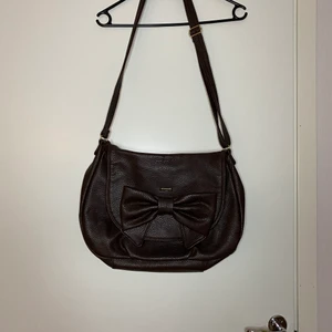 Brun väska med rosett  - Gott skick, stängs med magnet. Axelband. Tar endast swish