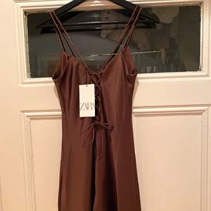 Jättefin brun silkesklänning från Zara. Med snören baktill och dubbla axelband. Helt ny med prisklapp kvar. Nypris: 399kr. Skriv för mer bilder😊