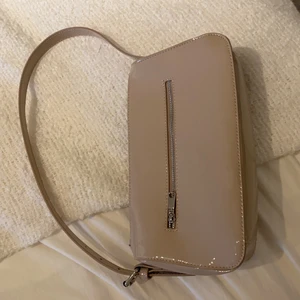 Glansig väska i beige  - En helt oanvänd väska i en fin beige färg💞