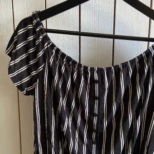 Randig bus - Svart-/vitrandig blus med knappar, lite croppad och går att ha off-shoulder🖤🤍 Strl M