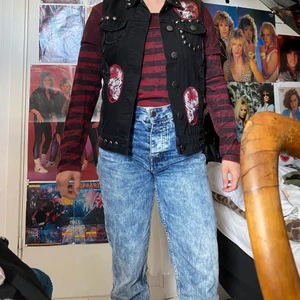 Väst med tryck - Cool väst med tryck och nitar ifrån rock rebel by emp. Knappt använd och i fint skick. Katt i hemmet. Flertal fickor 3 framtill och två innerfickor. 