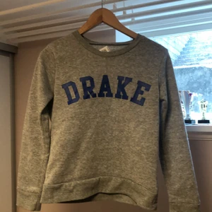 Grå DRAKE sweatshirt: S - En Grå basic sweatshirt med ett tryck där det står DRAKE i blått💎säljer denna då den är för liten  Storlek: S