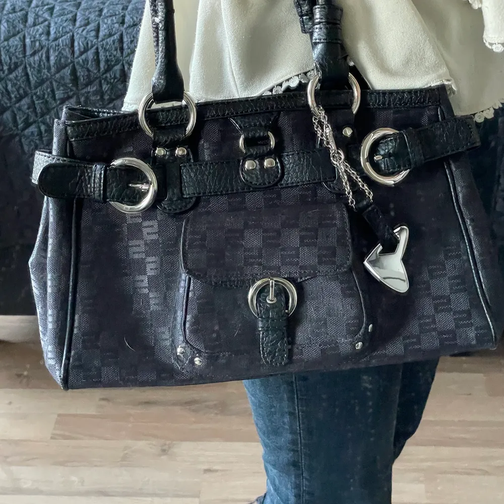 Supersnygg och trendig vintage väska från Sisley. Rymmer mycket och super fina silver detaljer! Dock ganska använd vilket resultat i defekter på handtaget. Köpt för 600kr. Väskan har supercoola detaljer över hela väskan med märkes logga. Fråga för fler bilder! (Kunden står för frakten). Laukut & Käsilaukut.