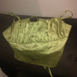 Grön topp - En grön silkes topp med snörning i ryggen ifrån SHEIN i str 36. Köparen står för frakt.