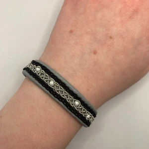 Tenntrådsarmband  - Handgjort Tenntrådsarmband, grått med vita pärlor. Materialet armbandet är gjort i är lammskinn, och flätan är gjort i tenntråd. Armbandet kan hålla i flera år. Om du har någon fråga kan du gärna skriva en kommentar eller meddela mig.