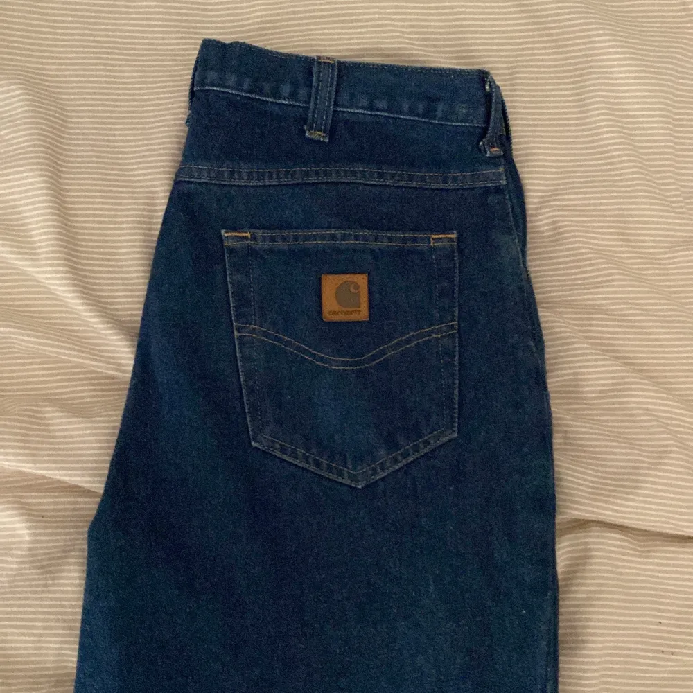 Mörkblå Carhartt jeans i storlek 34x30. Jeansen har avslappnad och rak passform. Jeans & Byxor.