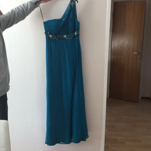 Festklänning - Fin och elegant festklänning som använts bara en gång. Säljes pga för stor i storlek. Den är inte gammal och i mycket bra skick. Självklart är den kemtvättad som alla andra klänningar.