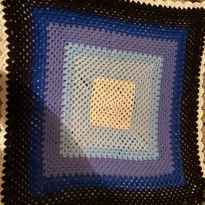 En virkad bebies täcke  - En virkad bebies täcke som passar till nyfödda barn från första månaden till 1 år gammal. Färge: vitt, nyanaser av blå och svart. 